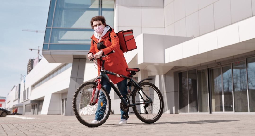 Entregador por aplicativo com bag e bicicleta